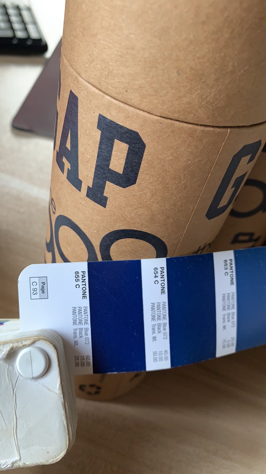 Original photograph of a printed kraft tube beside Pantone colour references