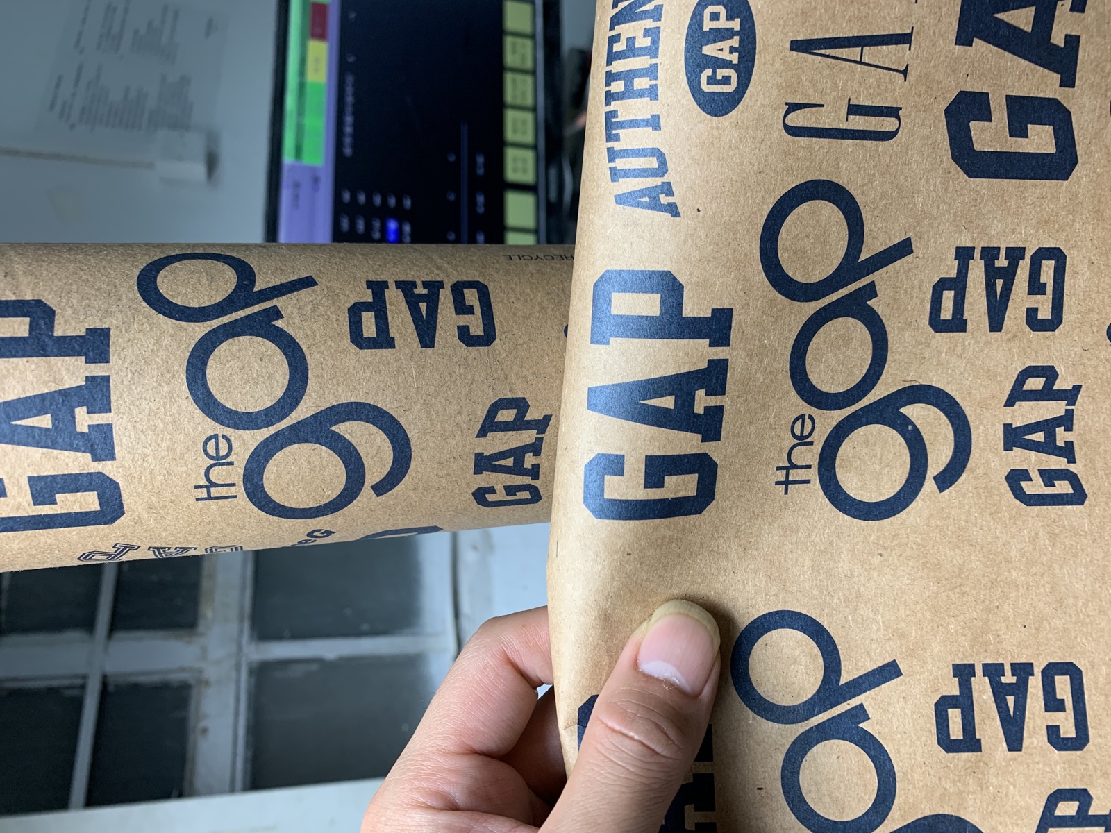 Original close-up photograph of artwork placement on a printed kraft tube
