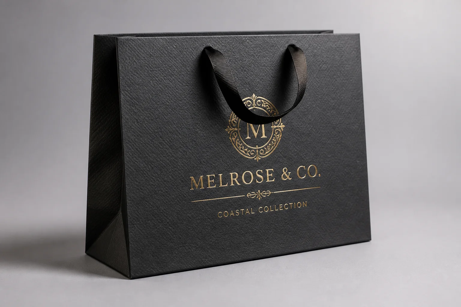 Black luxury paper bag with gold-coloured lettering
